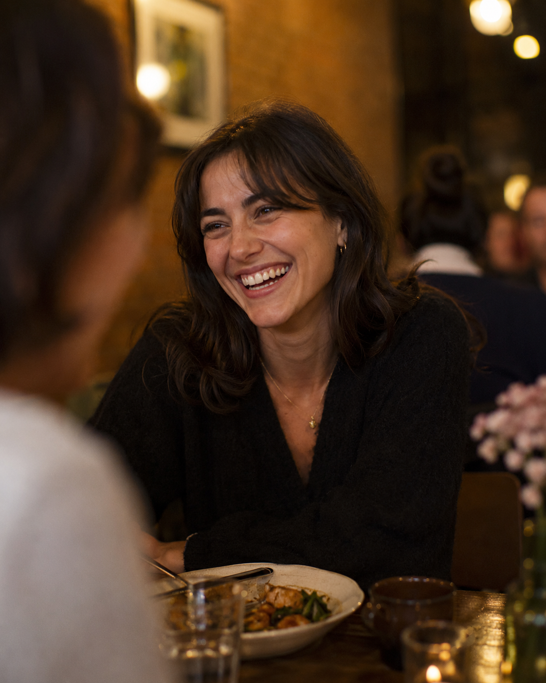 Woman laughing over dinner